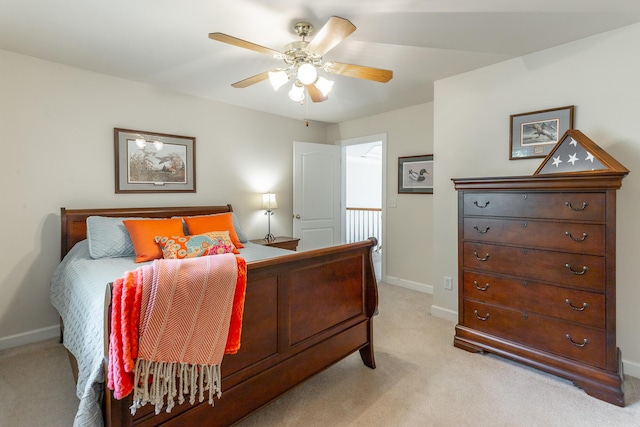 bedroom with light colored carpet, baseboards, and a ceiling fan