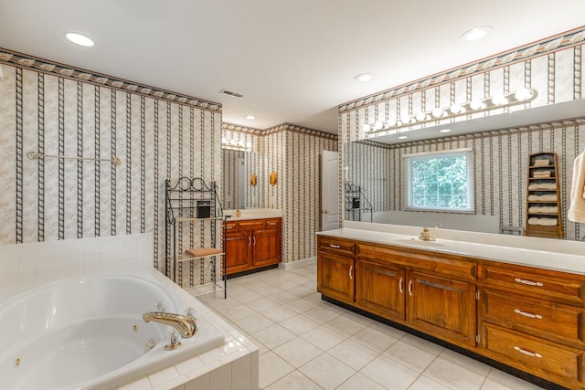 bathroom with wallpapered walls, tile patterned floors, vanity, a jetted tub, and recessed lighting