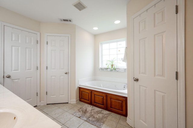 bathroom featuring a bath, tile patterned floors, vanity, and baseboards