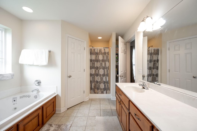 bathroom with tile patterned floors, vanity, a jetted tub, and baseboards