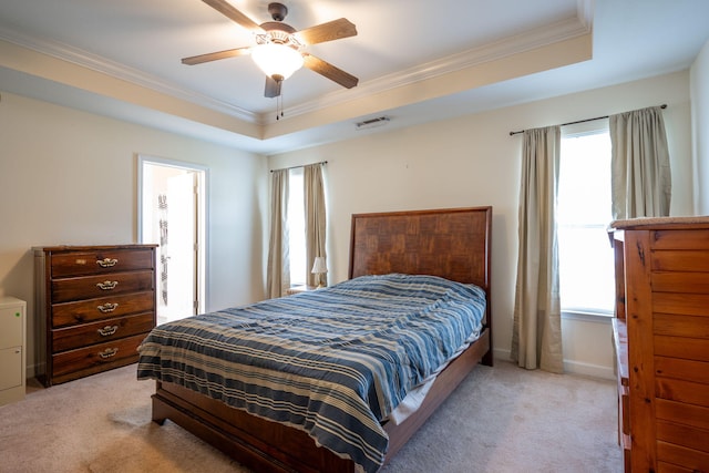 bedroom with light carpet, multiple windows, crown molding, and a tray ceiling