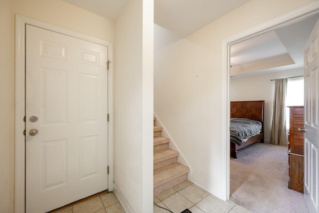 foyer entrance with light tile patterned floors, baseboards, and stairs