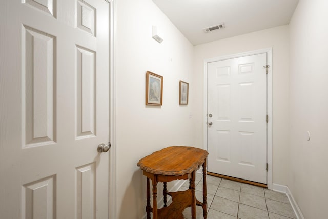 doorway to outside featuring light tile patterned flooring and baseboards