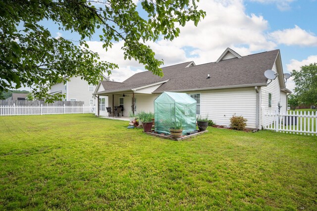 rear view of property featuring a ceiling fan, a patio, and roof with shingles