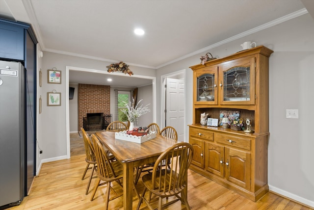 1123 Ridgeleigh Cir, Dalton, GA 30720 - dining space featuring light wood finished floors, crown molding, a fireplace, baseboards, and recessed lighting
