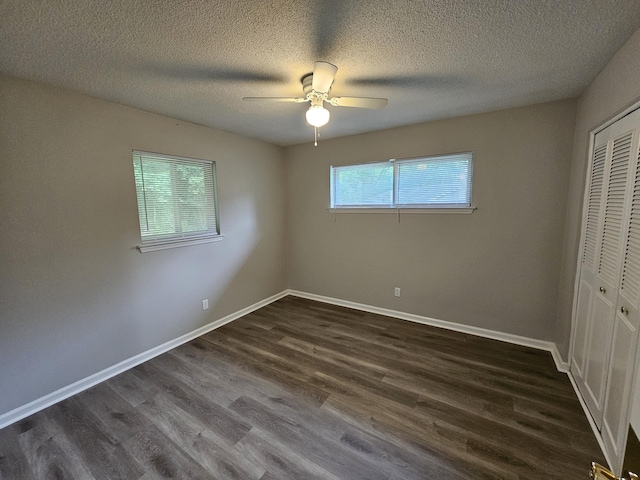 4458 Norcross Rd, Hixson, TN 37343 - unfurnished bedroom featuring dark wood-type flooring, a closet, baseboards, a textured ceiling, and a ceiling fan