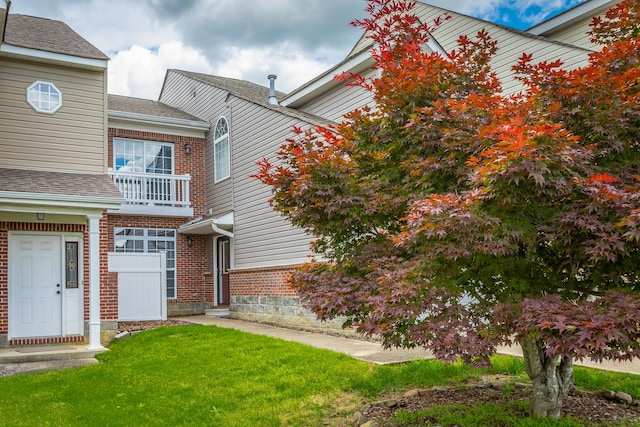 7817 Legacy Park Ct, Chattanooga, TN 37421 - view of front facade with a balcony, brick siding, a front yard, and roof with shingles