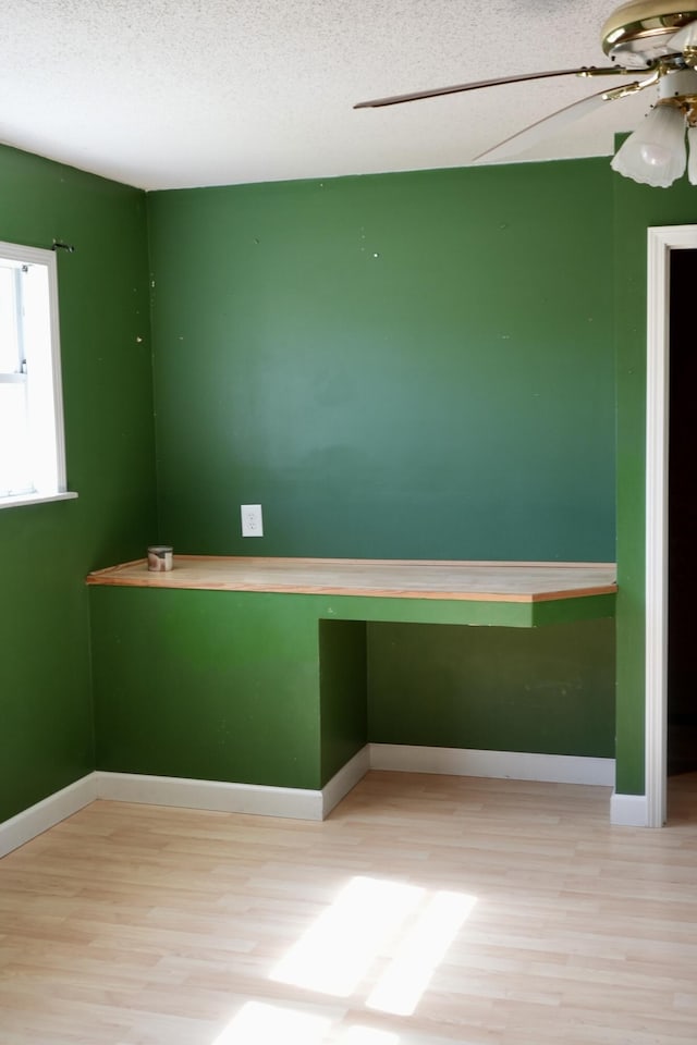 708 8th St, Bridgeport, AL 35740 - empty room with wood finished floors, a ceiling fan, a textured ceiling, and baseboards