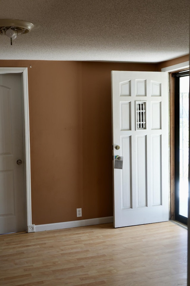 708 8th St, Bridgeport, AL 35740 - entryway featuring light wood-type flooring, a textured ceiling, and baseboards