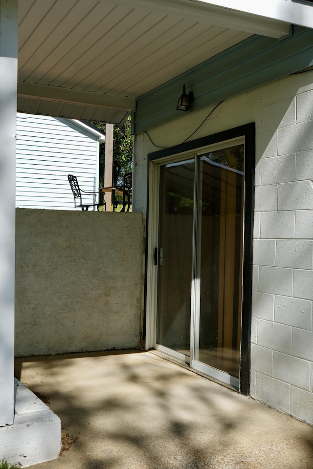 708 8th St, Bridgeport, AL 35740 - view of exterior entry with concrete block siding and a patio