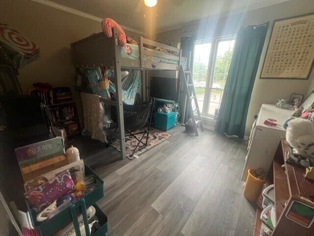bedroom featuring wood finished floors and crown molding