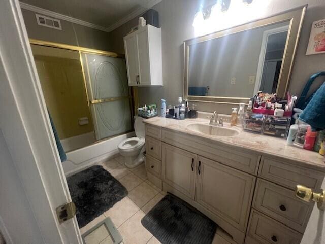 full bathroom with ornamental molding, tile patterned flooring, vanity, toilet, and bath / shower combo with glass door