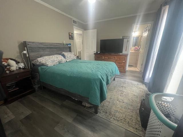 bedroom featuring ornamental molding, wood finished floors, and ensuite bathroom
