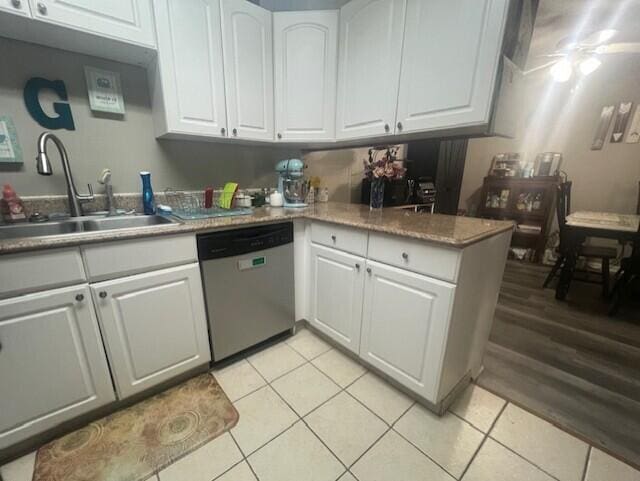 kitchen with dishwasher, a sink, white cabinets, light tile patterned flooring, and light countertops