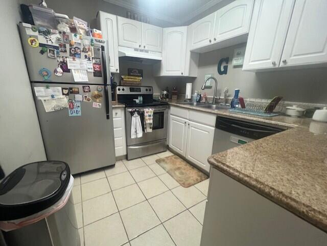 kitchen featuring stainless steel appliances, under cabinet range hood, white cabinetry, light tile patterned flooring, and a sink