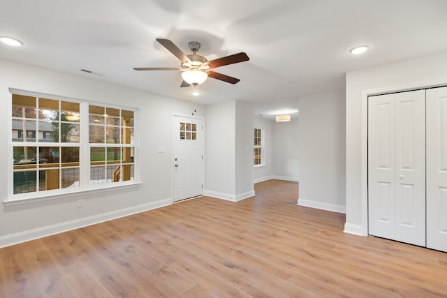 entrance foyer featuring baseboards, a ceiling fan, and light wood-style flooring