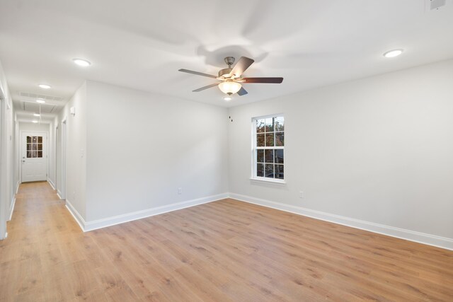 empty room with light wood-type flooring, baseboards, a ceiling fan, attic access, and recessed lighting