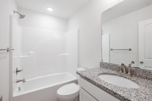 bathroom featuring toilet, vanity, and bathtub / shower combination