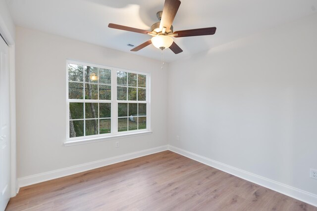 unfurnished room with light wood finished floors, baseboards, and ceiling fan