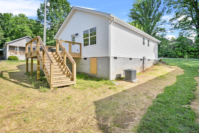 rear view of house featuring stairs, cooling unit, a wooden deck, and a lawn