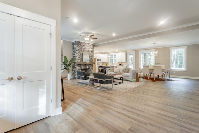 11570 Armstrong Rd, Soddy Daisy, TN 37379 - living area with crown molding, a ceiling fan, light wood-type flooring, baseboards, and a fireplace