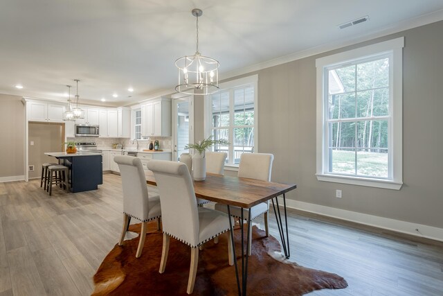 11570 Armstrong Rd, Soddy Daisy, TN 37379 - dining space with a chandelier, ornamental molding, healthy amount of natural light, baseboards, and light wood finished floors