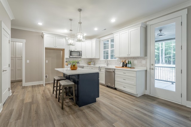 11570 Armstrong Rd, Soddy Daisy, TN 37379 - kitchen with appliances with stainless steel finishes, tasteful backsplash, light wood-style flooring, white cabinetry, and a breakfast bar area