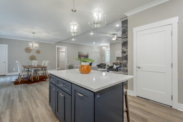 11570 Armstrong Rd, Soddy Daisy, TN 37379 - kitchen featuring ornamental molding, light wood finished floors, a ceiling fan, light countertops, and a center island