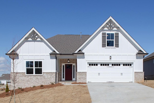 view of front of house with board and batten siding, brick siding, driveway, and a garage