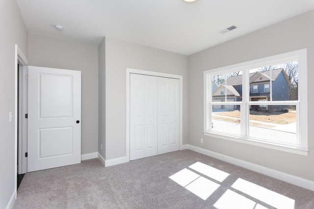 unfurnished bedroom with carpet flooring, baseboards, and a closet