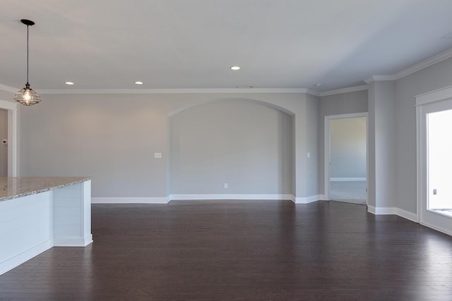 unfurnished living room with arched walkways, dark wood finished floors, crown molding, recessed lighting, and plenty of natural light