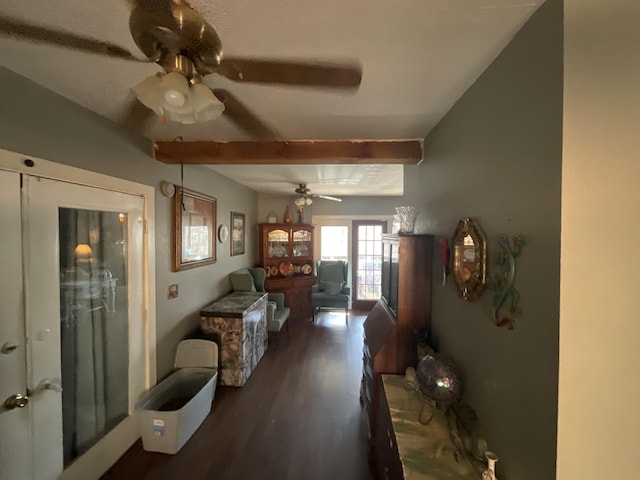 living room with ceiling fan, wood finished floors, and beamed ceiling
