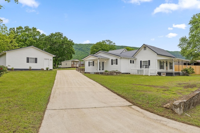 1445 N Main St, Whitwell, TN 37397 - view of front facade featuring concrete driveway, a front lawn, metal roof, and covered porch