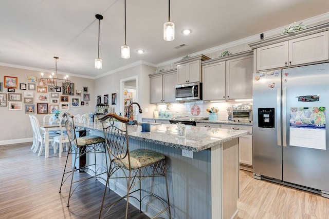 231 Winchester Dr, Rossville, GA 30741 - kitchen with stainless steel appliances, a breakfast bar, light wood-type flooring, tasteful backsplash, and light stone counters