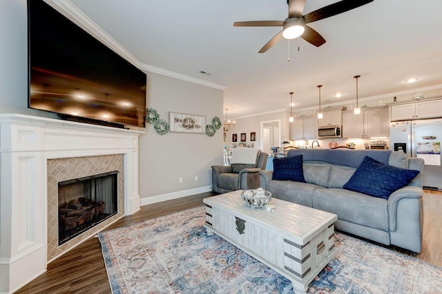 231 Winchester Dr, Rossville, GA 30741 - living room with dark wood-style floors, a ceiling fan, ornamental molding, a tile fireplace, and baseboards