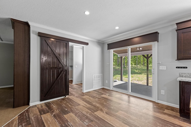 201 County Line Rd, Signal Mountain, TN 37377 - unfurnished living room featuring baseboards, ornamental molding, dark wood-type flooring, a textured ceiling, and a barn door