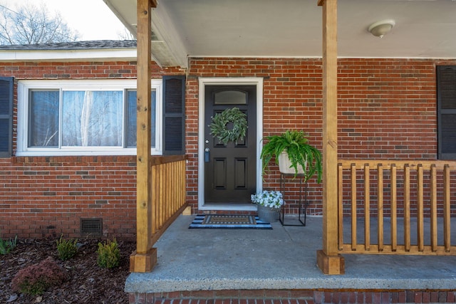 doorway to property featuring brick siding and crawl space