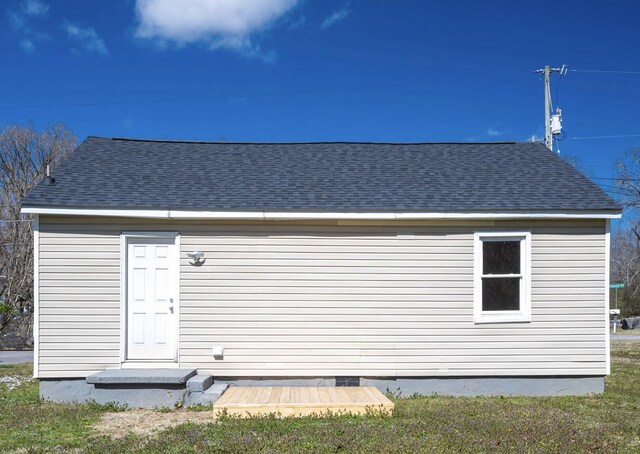 rear view of property with roof with shingles