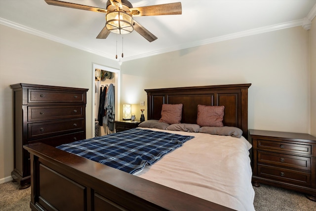 bedroom with carpet flooring, ornamental molding, a closet, a walk in closet, and a ceiling fan