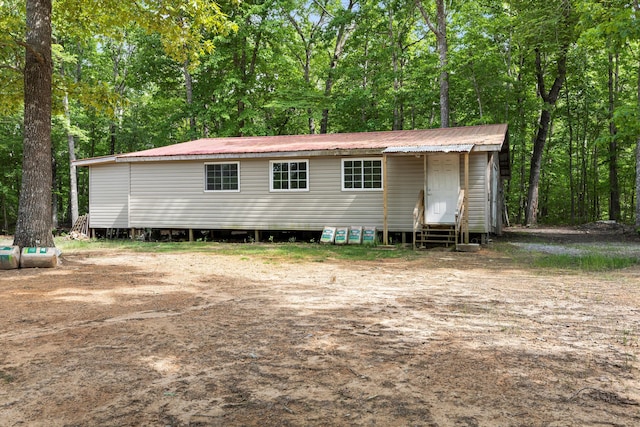 exterior space featuring entry steps and metal roof