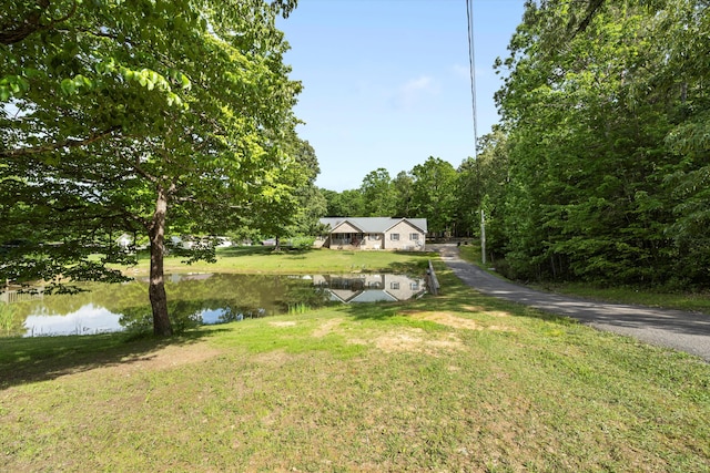 view of green lawn with a water view