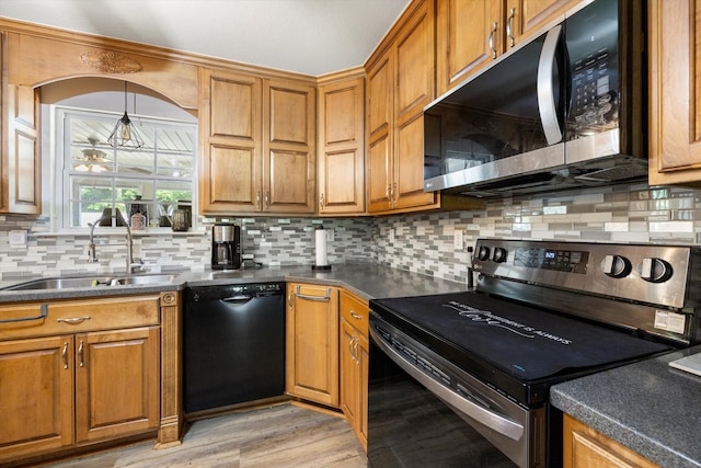 kitchen with stainless steel microwave, range with electric stovetop, dishwasher, a sink, and dark countertops