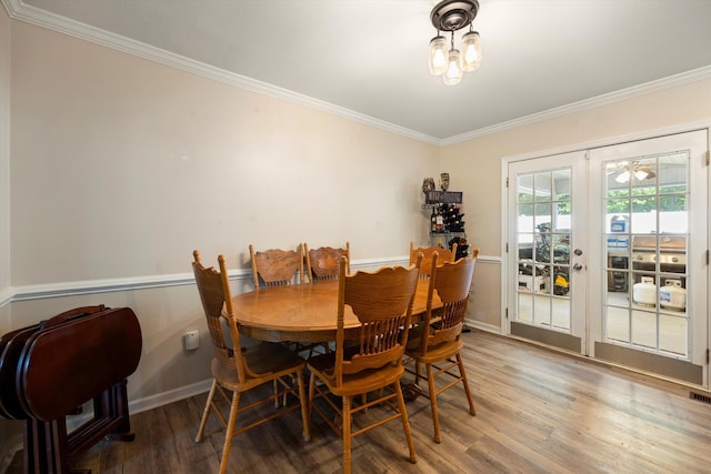 dining space with crown molding, wood finished floors, french doors, and baseboards
