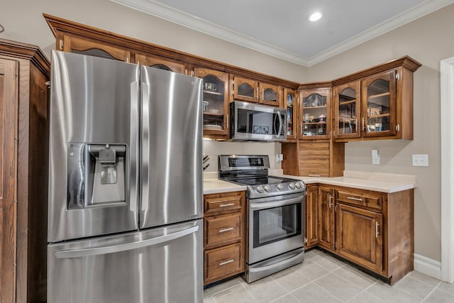 2123 Sargent Quick Dr, Chattanooga, TN 37421 - kitchen with stainless steel appliances, light countertops, light tile patterned floors, brown cabinetry, and ornamental molding