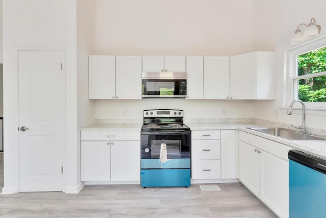 3910 Brock Rd, Chattanooga, TN 37421 - kitchen with stainless steel appliances, white cabinetry, light countertops, light wood finished floors, and a towering ceiling
