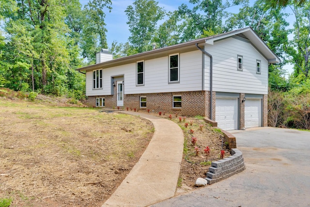 3910 Brock Rd, Chattanooga, TN 37421 - split foyer home with a chimney, asphalt driveway, a garage, and brick siding