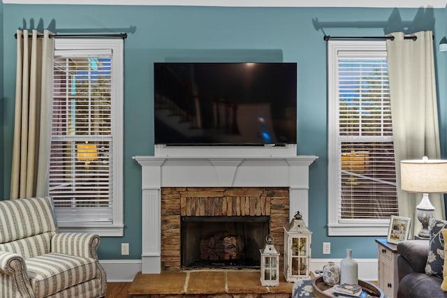 8802 Mckenzie Farm Dr, Ooltewah, TN 37363 - living room featuring a fireplace with raised hearth, wood finished floors, and baseboards