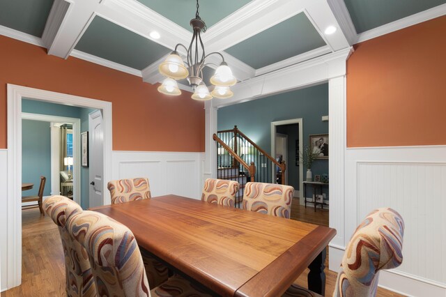 8802 Mckenzie Farm Dr, Ooltewah, TN 37363 - dining room with coffered ceiling, a chandelier, wainscoting, ornamental molding, and stairway