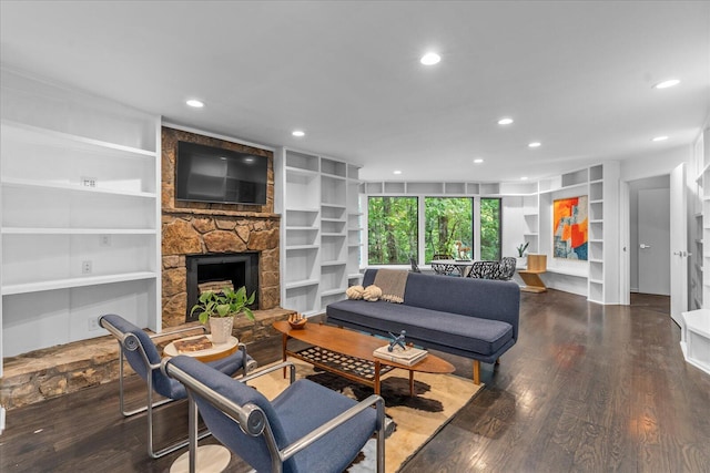 living room featuring built in features, a stone fireplace, wood finished floors, and recessed lighting