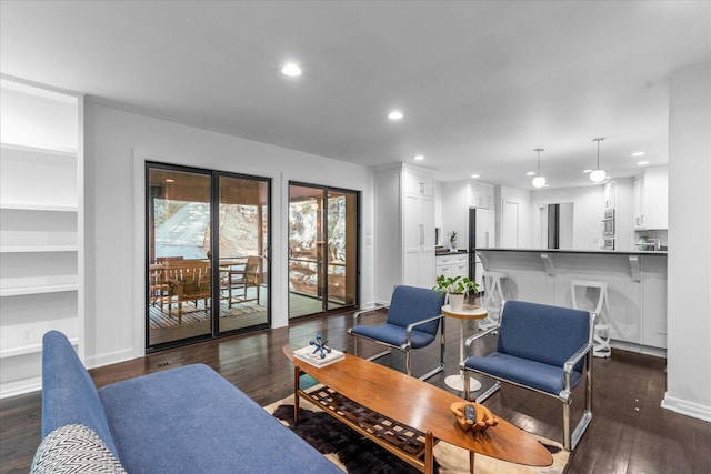 living room featuring recessed lighting, dark wood-style flooring, baseboards, and built in shelves